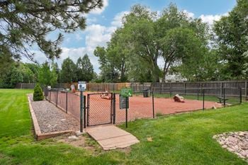 A tennis court surrounded by a fence and trees